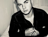 a black and white photo of a man sitting on a bed