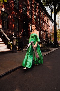 a woman in a green dress walking down a street