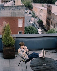 a man sitting on a chair on a rooftop