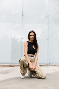 a woman crouching in front of a glass wall