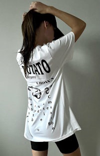a woman wearing a white t - shirt with words on it