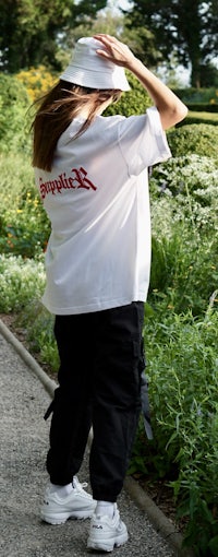 a woman wearing a white t - shirt and black pants