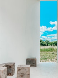 a white room with wooden benches and a view of the sky