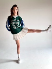 a young woman in a green and white jersey posing for a photo