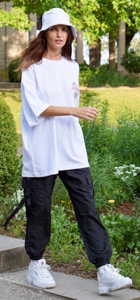 a woman wearing a white t - shirt and black pants
