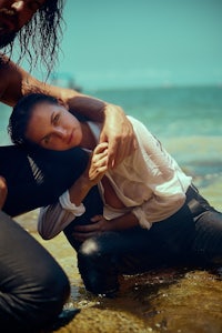 a man is holding a woman in the water