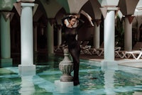 a woman in a black swimsuit posing in a pool