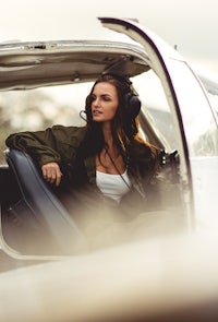 a woman sitting in the back seat of a small plane